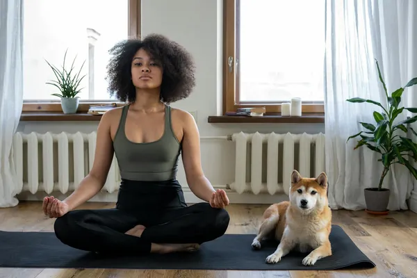 Persona estirando en posición de yoga sobre esterilla en casa