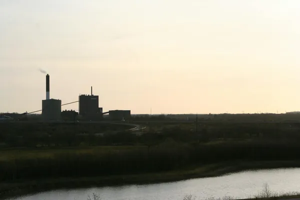 Central eléctrica con chimenea en un paisaje rural