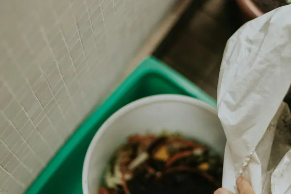 Compost casero con restos de verdura en un cubo verde
