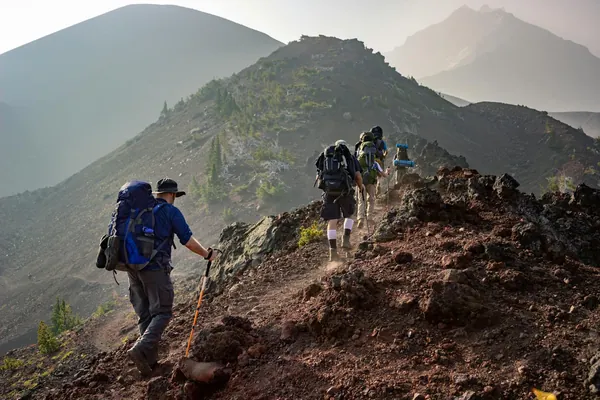 Senderistas con mochila recorriendo una cresta montañosa